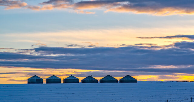 Grain Storage Bins in a Cold Winter Sunset snow on the ground